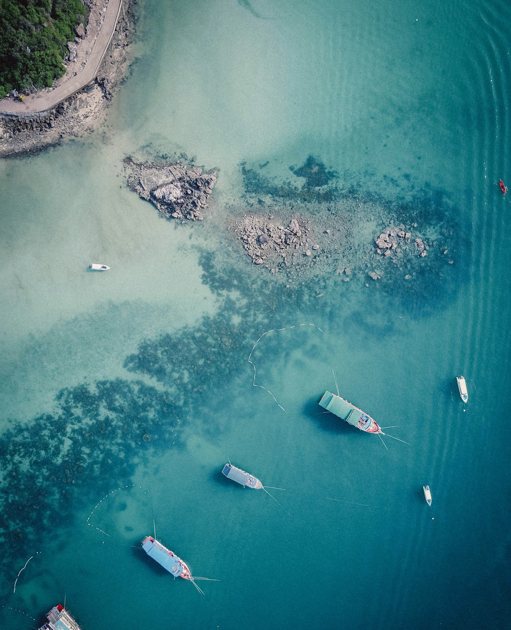 aerial photo of boats anchored on shallow waters near beach during daytime