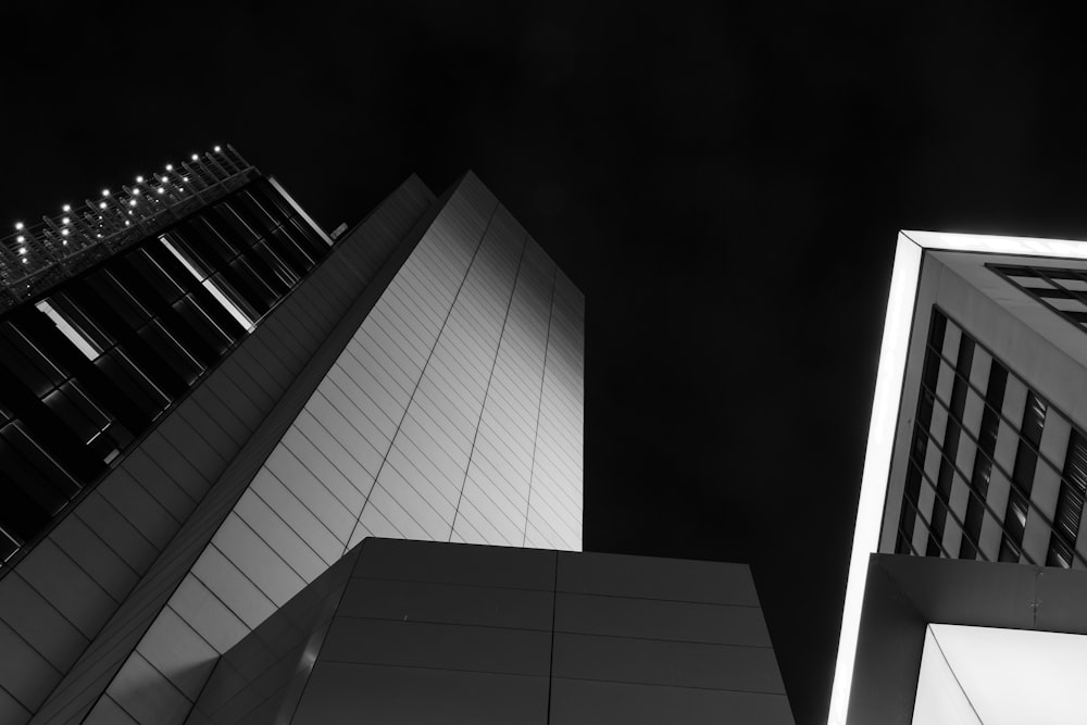 low angle photography of high-rise curtained wall building grayscale photo