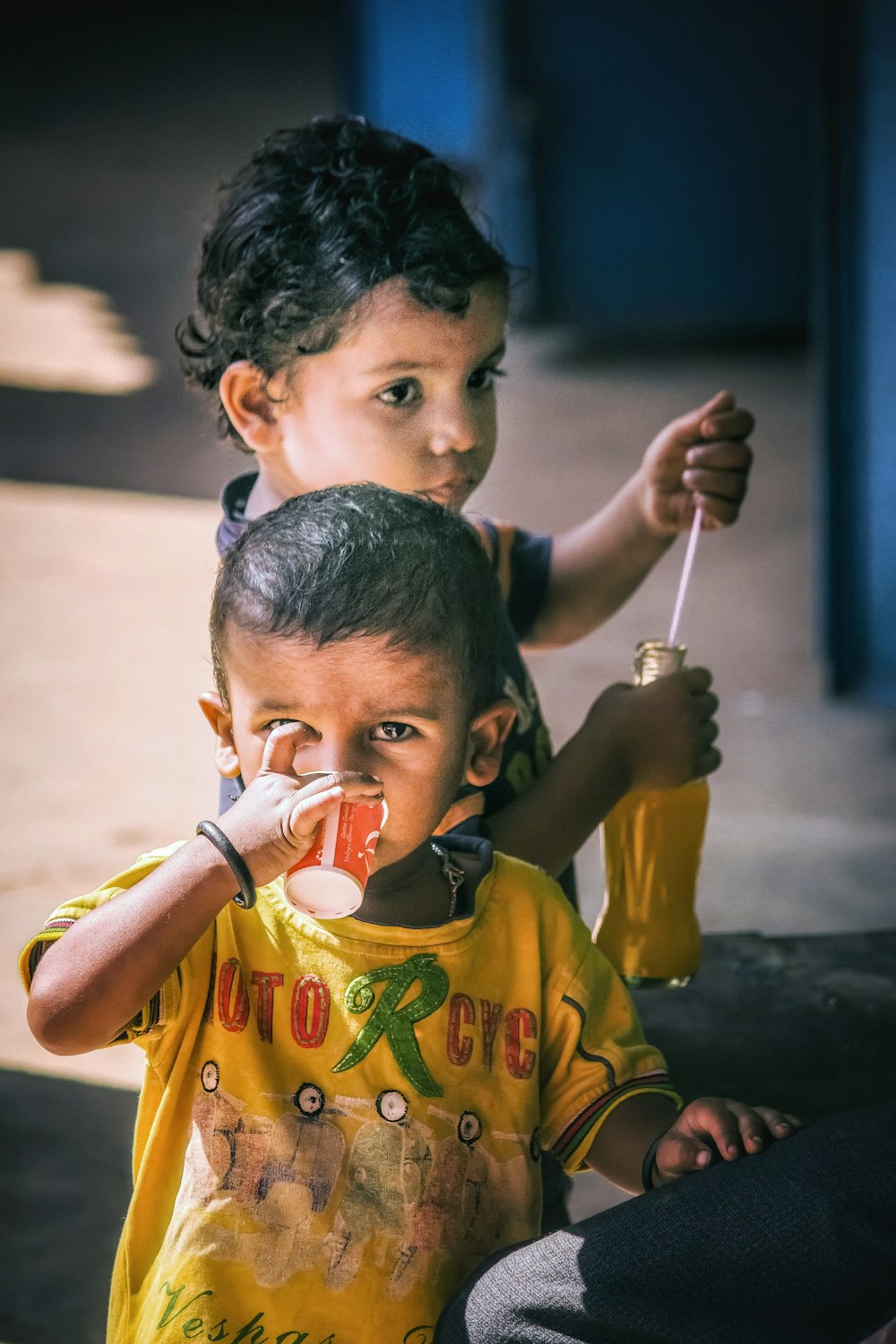 boy in yellow T-shirt drinking