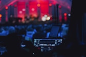 a stage with a laptop and microphone in front of a crowd