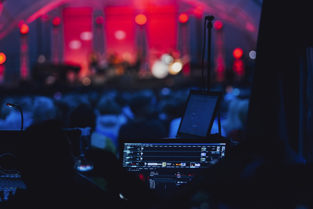 un palco con un computer portatile e un microfono di fronte a una folla