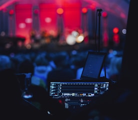 a stage with a laptop and microphone in front of a crowd