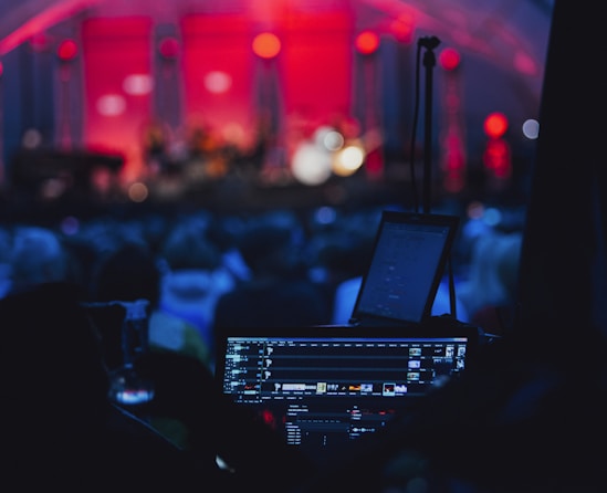 a stage with a laptop and microphone in front of a crowd