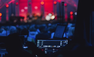 a stage with a laptop and microphone in front of a crowd