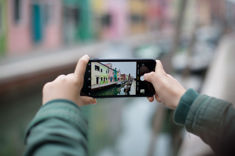 person taking photo in shallow photography