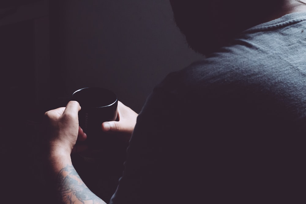 man holding black mug