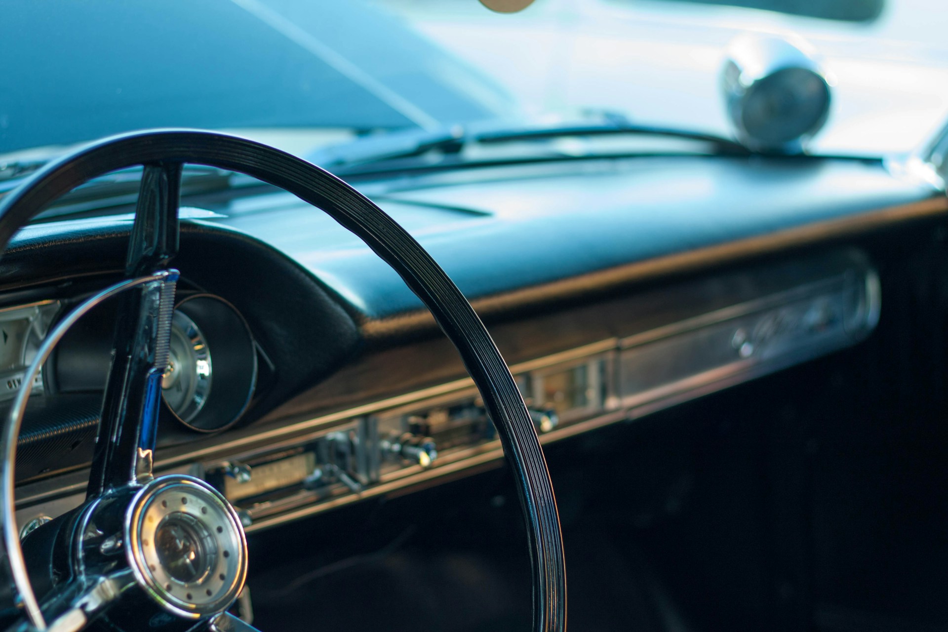 A close-up of a vintage car's polished chrome details and classic dashboard, evoking timeless style and craftsmanship.