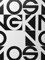 Bold black and white geometric typography with large, overlapping letters and shapes, creating an abstract pattern.