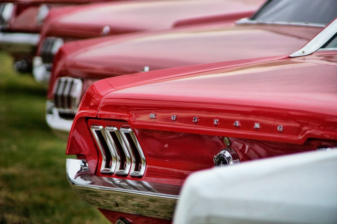 selective focus photography of parked red Ford Mustang cars