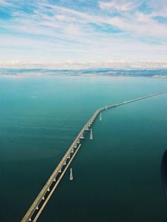 A panoramic view of a newly completed highway bridge spanning a wide river under a clear sky.