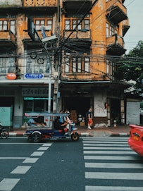blue auto rickshaw beside building at daytime
