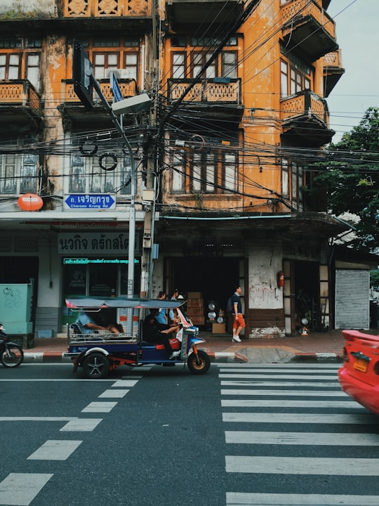 blue auto rickshaw beside building at daytime in Yaowarat Road Thailand