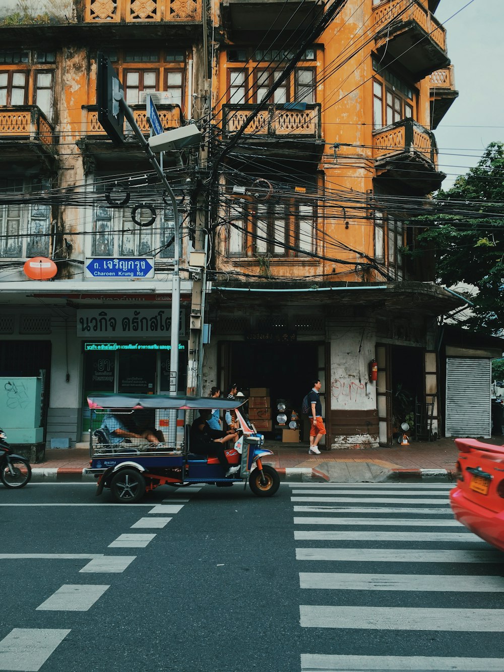 Rickshaw automático azul al lado del edificio durante el día