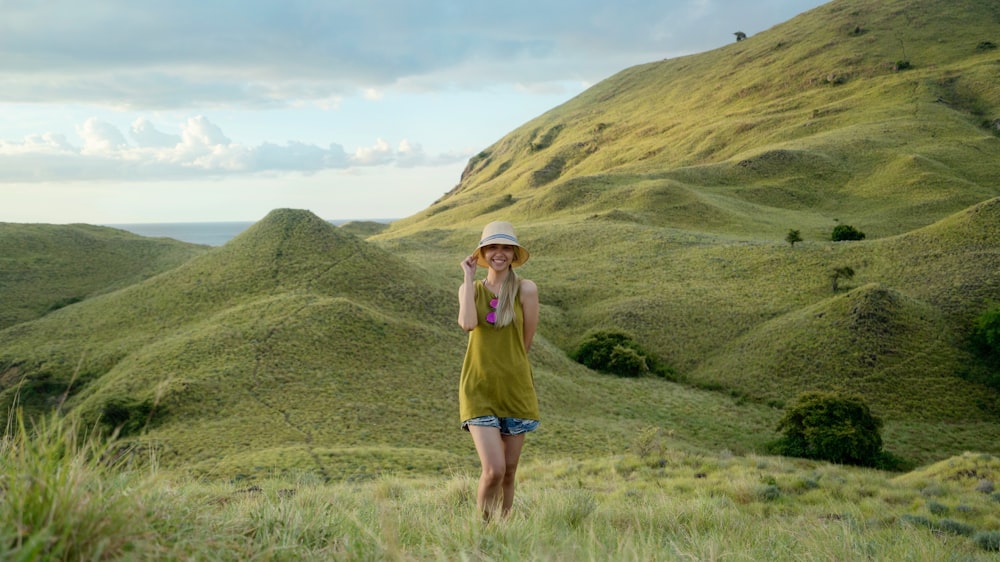 woman in green sleeveless top standing on mountain