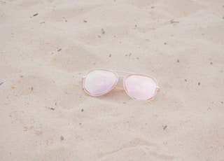 silver framed Aviator-style sunglasses on sand