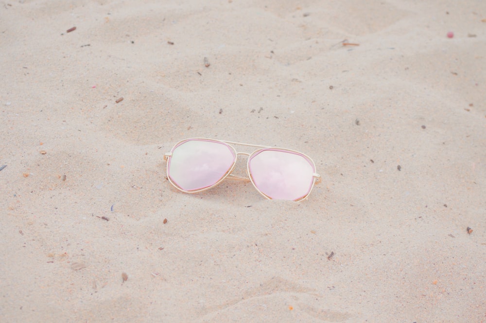 silver framed Aviator-style sunglasses on sand