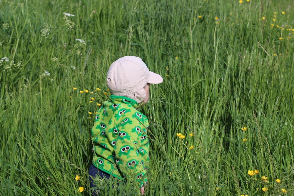 child walking on green grass field during daytime