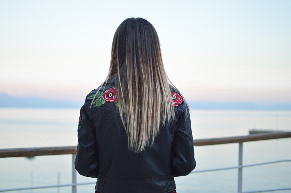 woman facing sea during blue hour