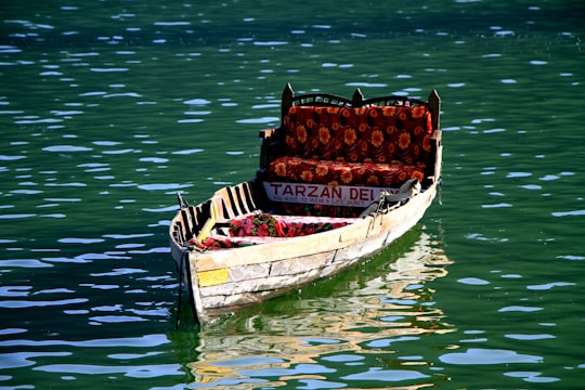 brown wooden boat on body of water in Nainital India