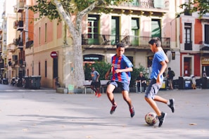 Children dribbling soccer balls in a vibrant community park.