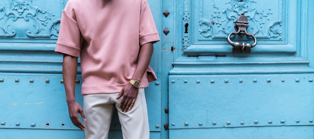 person standing beside blue painted wall