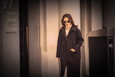 Model walking through a sunlit urban street wearing a minimalist, elegant outfit from Atelier Lumina.