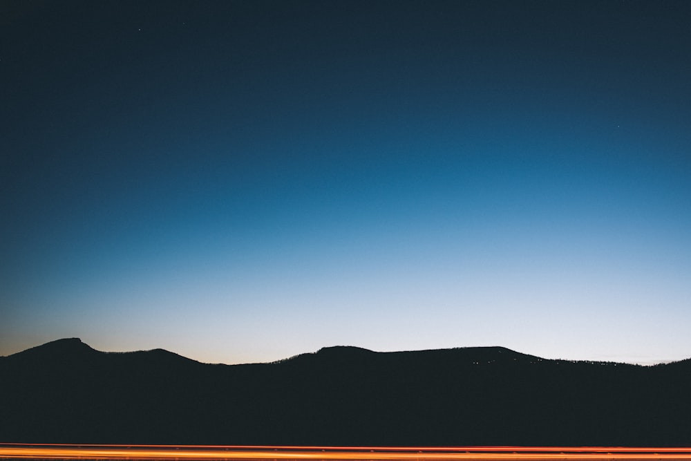 silhouette photography of mountain at blue hour