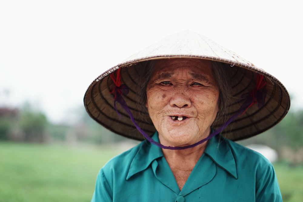 woman wearing woven hat standing near grass