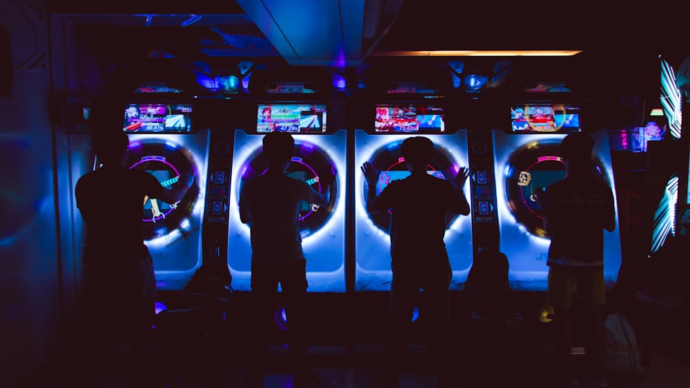 four people playing arcade game