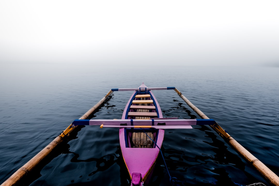 pink kayak on body of water