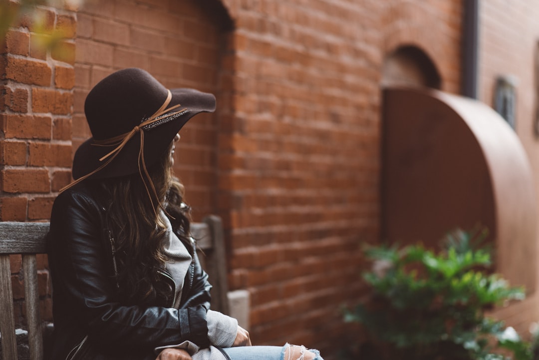 woman sitting on black wooden bench outdoor