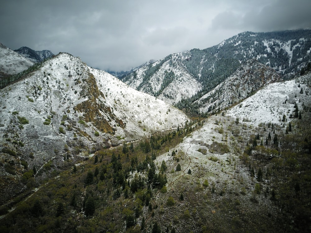 snow covered mountains under white clouds at daytime