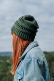 woman wearing green knit cap and blue denim jacket