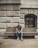 man sitting on concrete bench outside the building