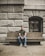 man sitting on concrete bench outside the building