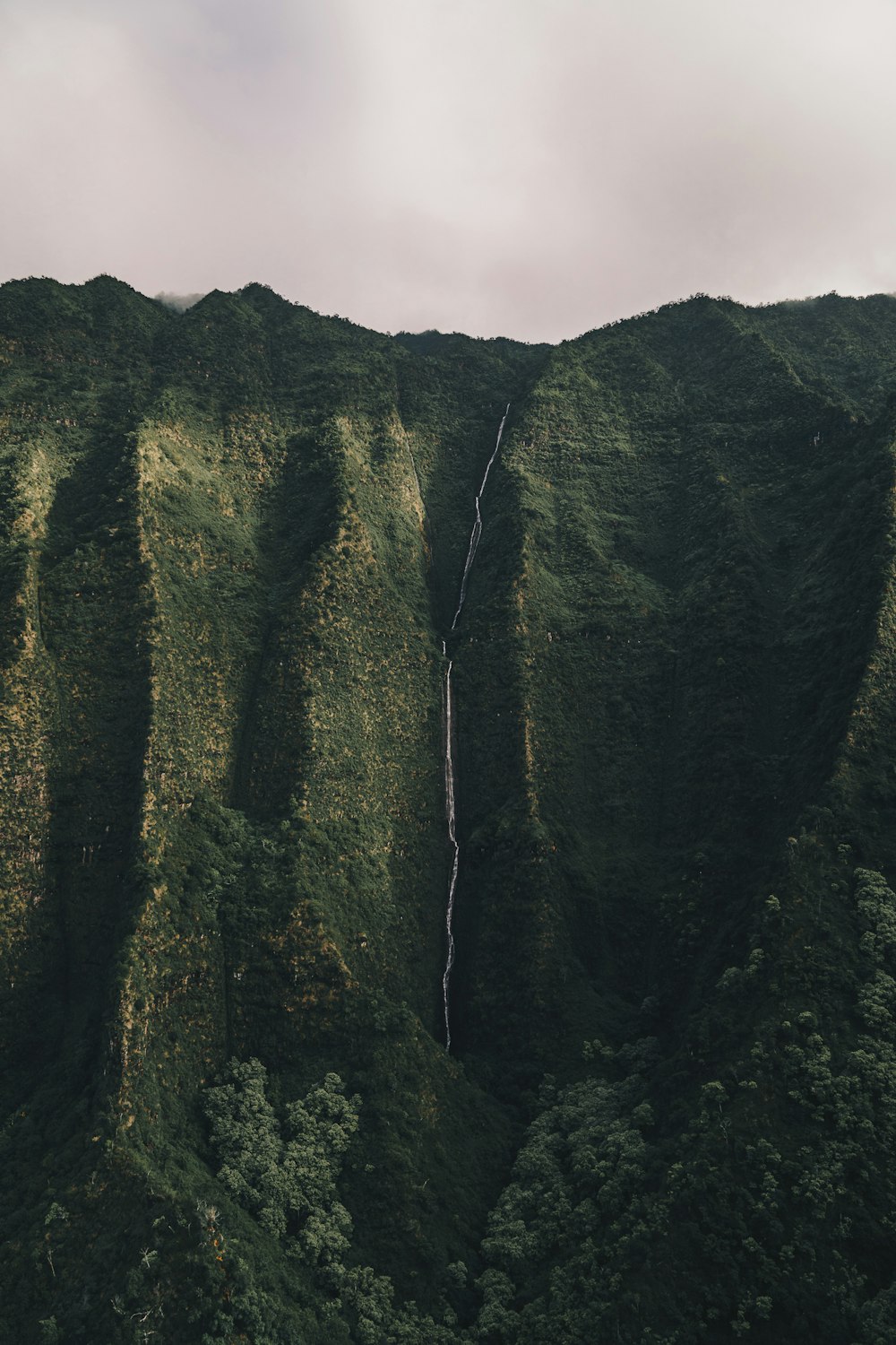 mountain cliff under white sky