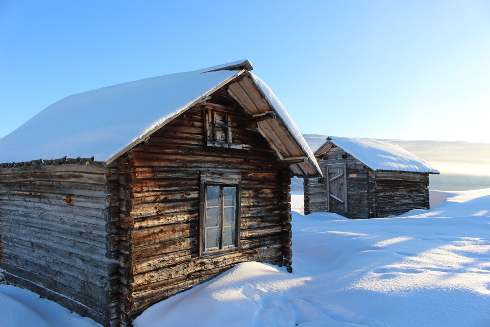 two wooden houses covered snow during daytime