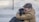 selective focus photography of man hugging black dog