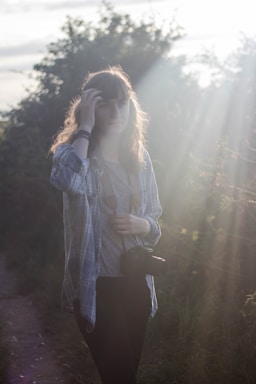 Model posing outdoors with natural background and soft lighting