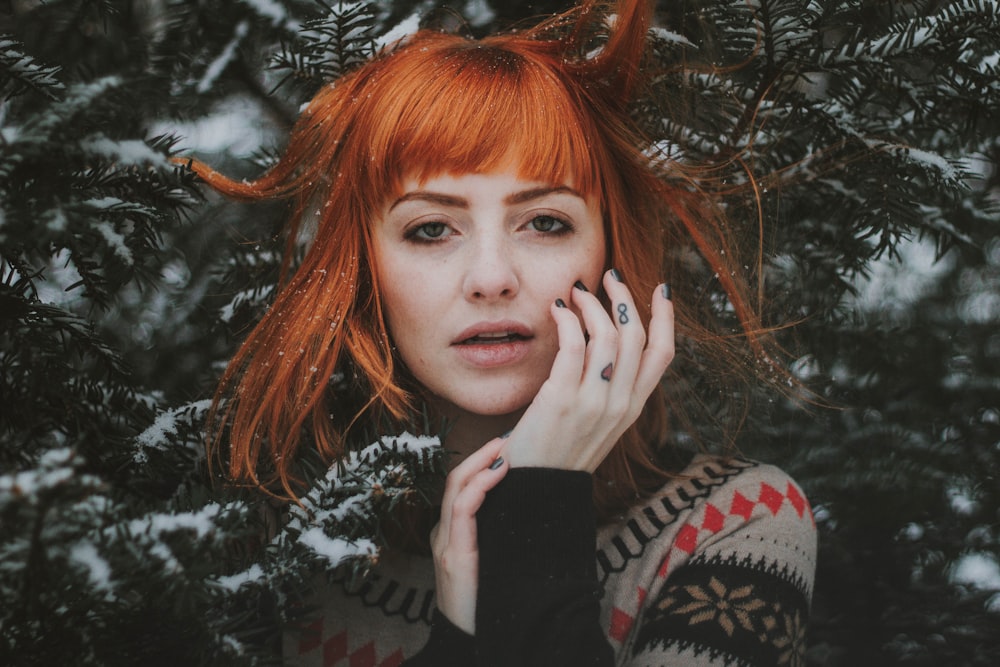 woman in front of tree covered snow during daytime