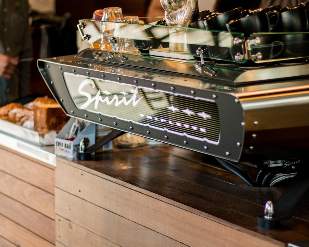 focus photography of Spirit Triplette machine on top of wooden counter