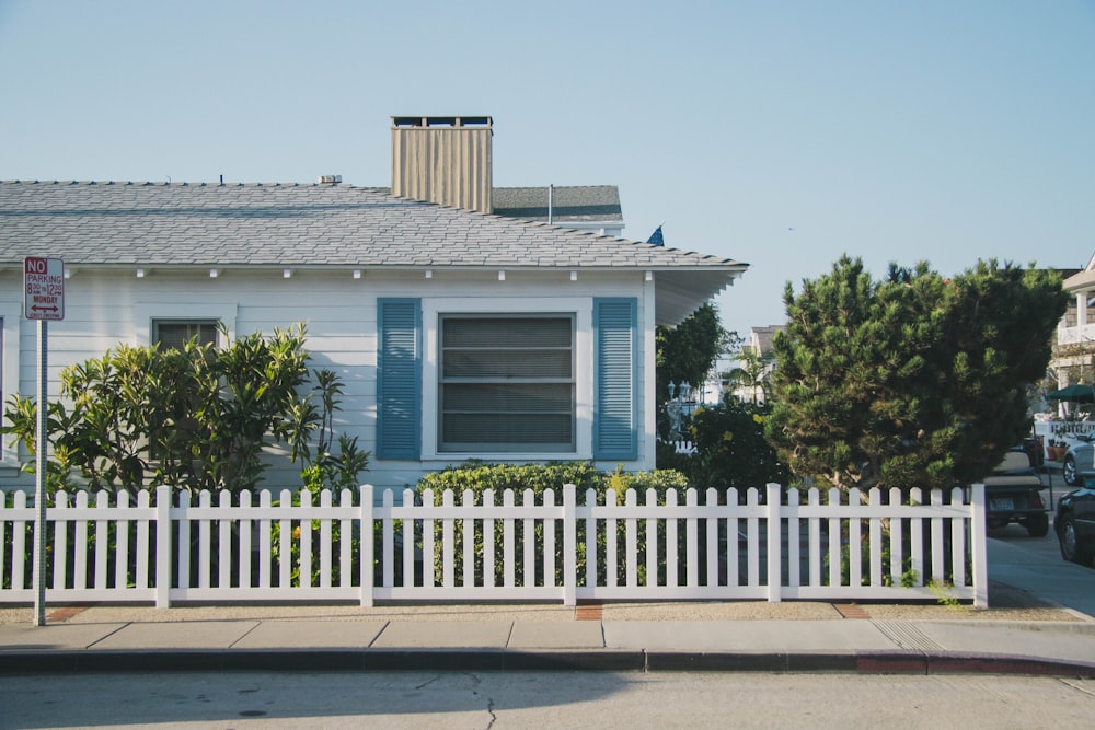 フェンスの横の白と青の家