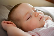 sleeping baby on gray cushion