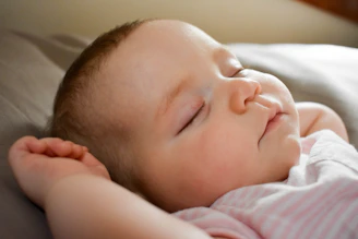 sleeping baby on gray cushion