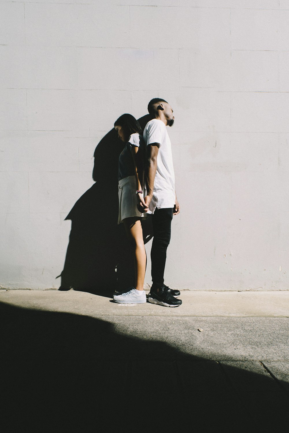 couple leaning on wall