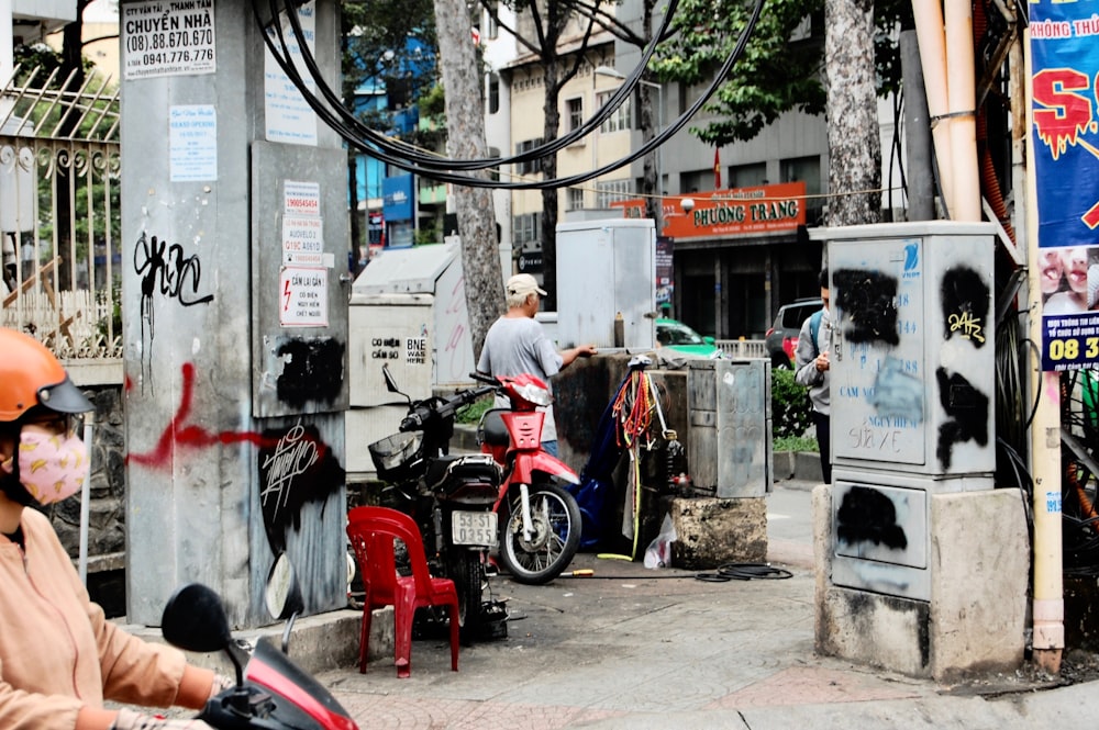 man riding on red motorcycle near buidling