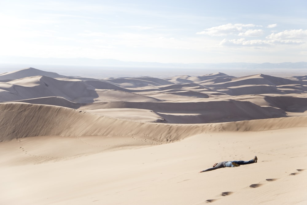 hombre acostado en el desierto durante el día