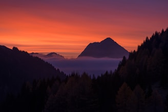 Sunset view over misty mountain peaks from a high trail.