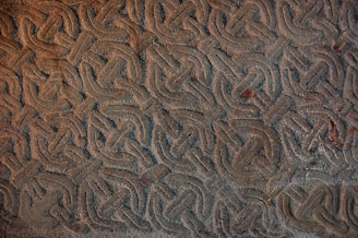 Detailed photograph of a Celtic stone carving with interlaced knot designs.