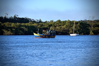 A vibrant fishing boat cutting through the calm blue sea at sunrise near Unawatuna.